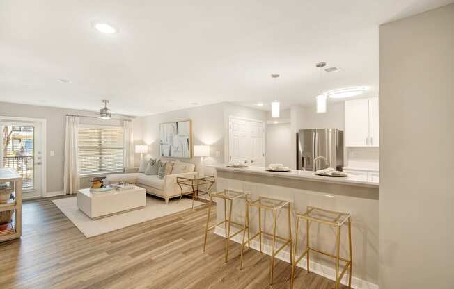 a living room with a kitchen and a couch and chairs at The Azul Apartment Homes, Oxford, Mississippi
