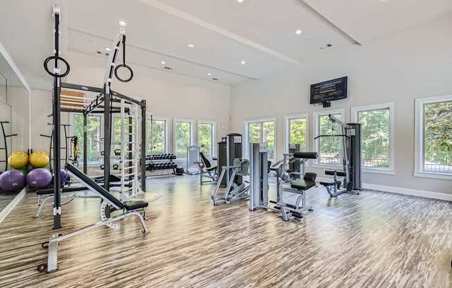 A spacious home gym with wooden floors and a variety of exercise equipment.