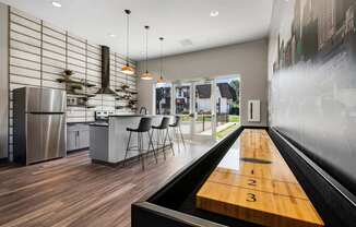 A modern kitchen with a shuffleboard table in the middle.