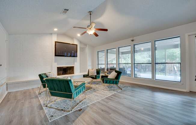 a living room with a large window and a ceiling fan