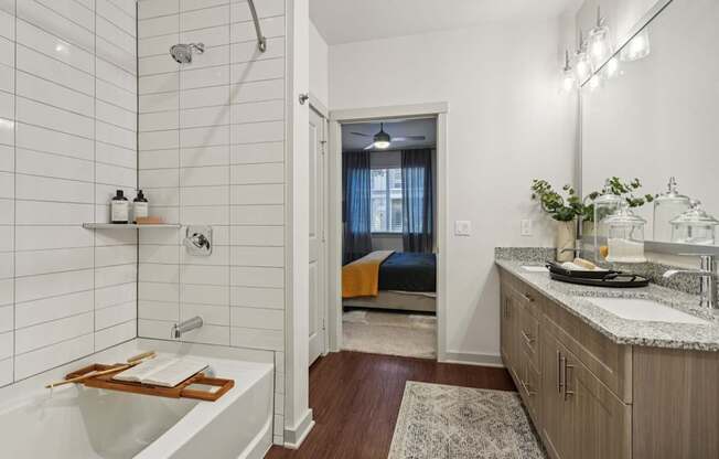 A bathroom with a white tub and a sink with a plant on the counter.