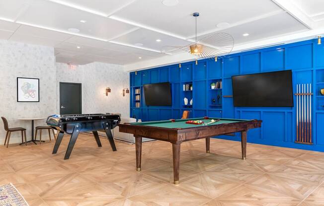 A room with a pool table and a TV.