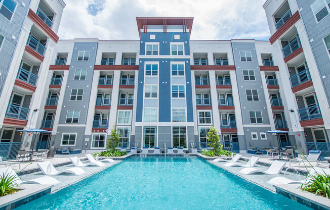 an apartment building with a large pool in front of it