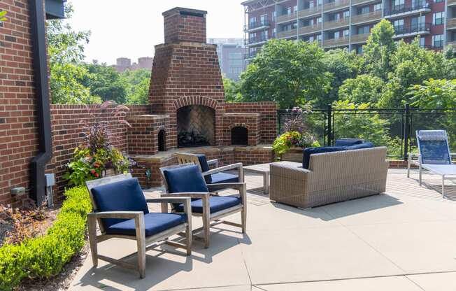 an outdoor patio with chairs and a fireplace