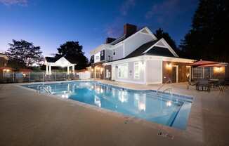 a swimming pool in front of a house at night