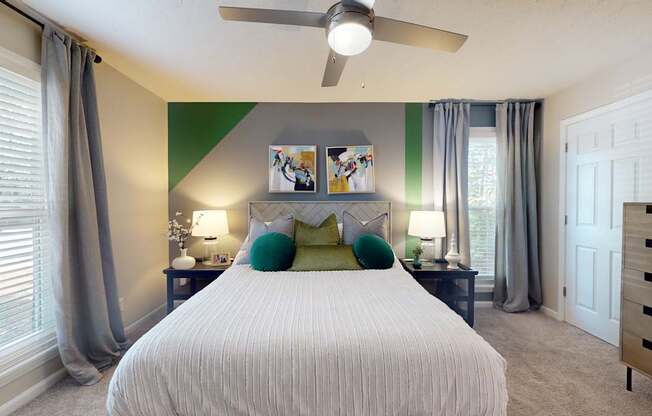 A bedroom with a large bed and a ceiling fan.
