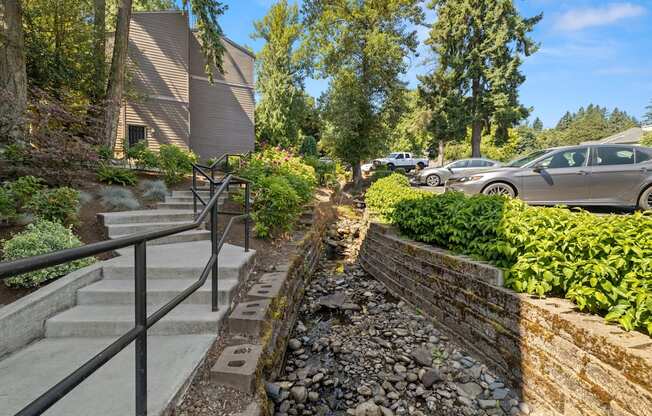 Running through a yard with a stone retaining wall and a stone wall with bushes and at Larkspur West Linn, West Linn, OR, 97068