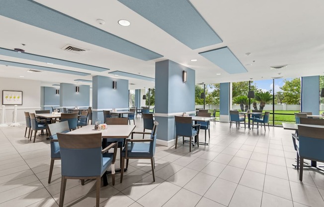 A large room with tables and chairs and a blue ceiling at Hampton Apartments, Clearwater 33759