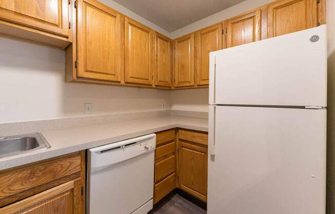 A kitchen with wooden cabinets and a white refrigerator.