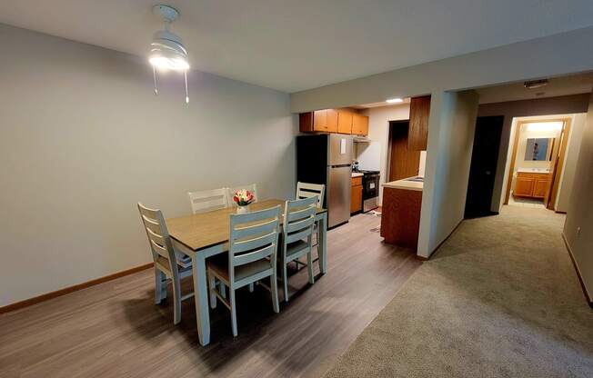 a dining room with a table and chairs and a kitchen