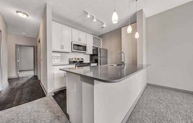 a kitchen with white cabinets and a gray counter top