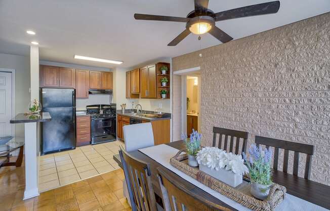 a dining room and kitchen with a table and a ceiling fan