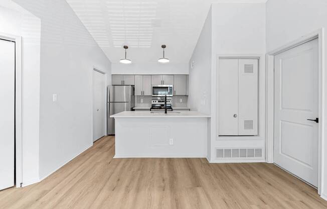 A kitchen with white cabinets and a white island.