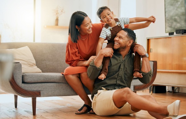 a family sitting on the floor in their living room