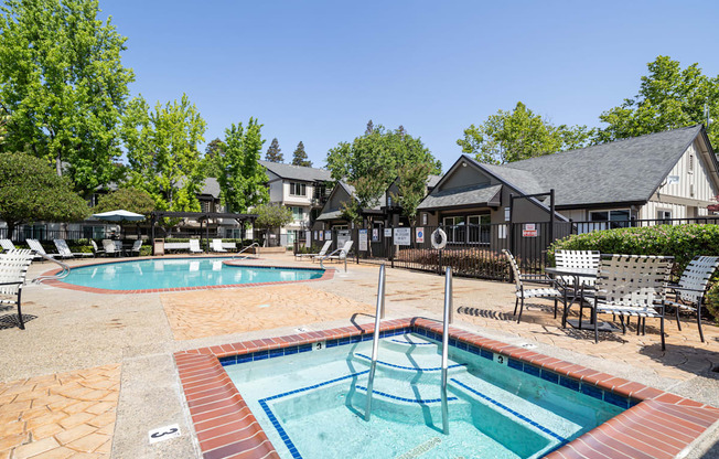 A pool with a slide and a hot tub.