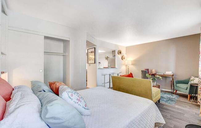 A bedroom with a bed, a desk, and a chair.