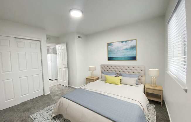 Carpeted bedroom with double sliding door closet on left and large window on right. Staged with queen-size bed and side tables.at Summit, Pocatello, 83201