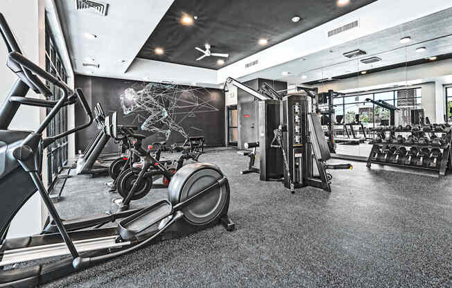 A gym with treadmills, elliptical machines, and other exercise equipment.