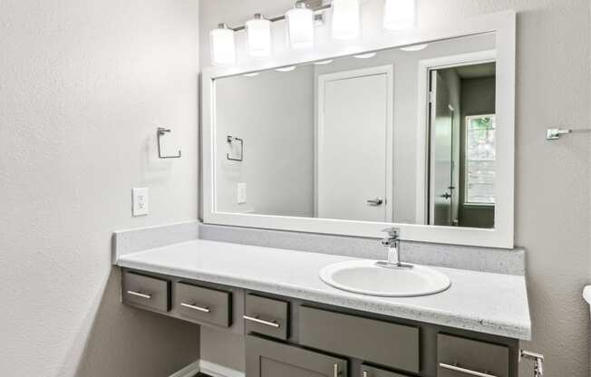 the retreat apartments renovated bathroom with sink and mirror
