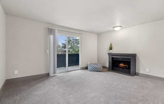 A room with a fireplace and a grey carpet.
