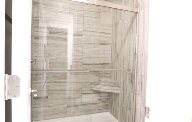 walk in shower with tiled backsplash