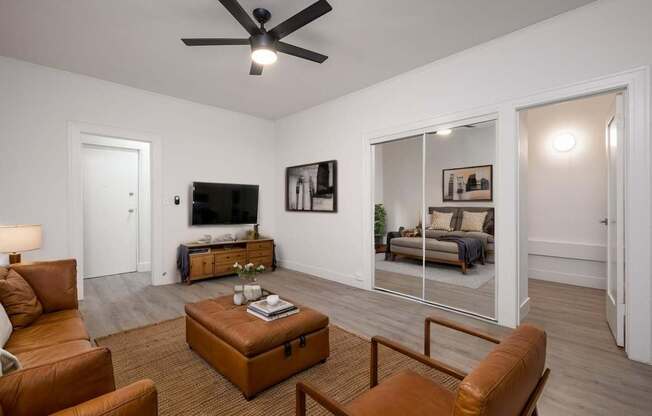 A living room with a brown leather chair and a brown ottoman at Westmore Manor Apartments, Los Angeles, CA, 90020