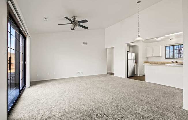 A spacious living room with a ceiling fan and carpeted floor at Tanglewood Apartments, Oak Creek, WI