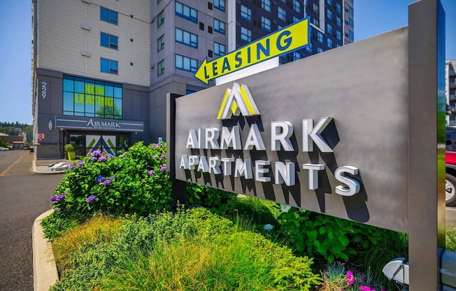 A sign for Airmark Apartments in front of a building with a