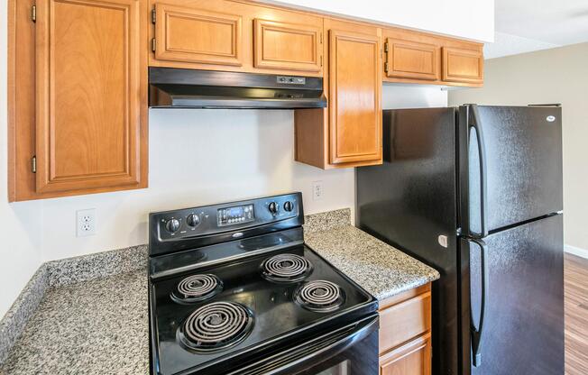 a stove top oven sitting inside of a kitchen with stainless steel appliances