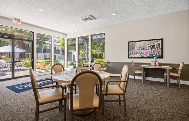 A room with a table and chairs and a painting on the wall.