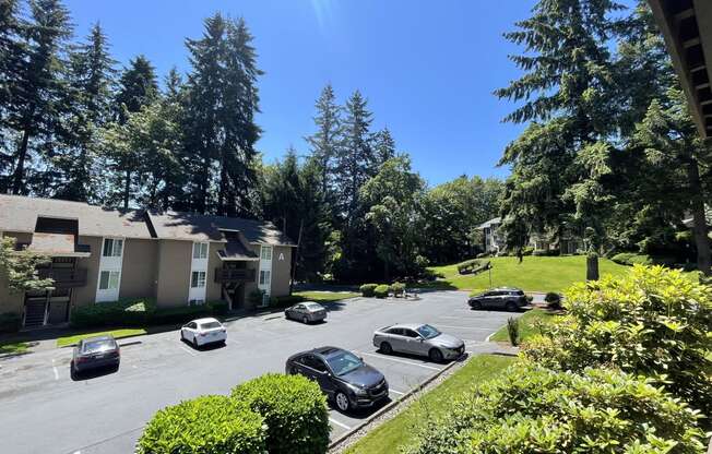 an aerial view of a parking lot with cars in front of houses