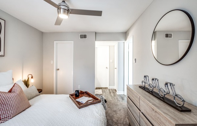 a bedroom with a bed and a dresser and a mirror