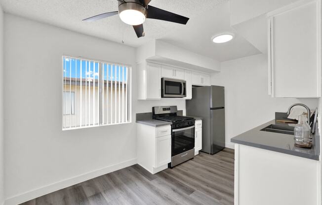 an open kitchen with a window and a ceiling fan