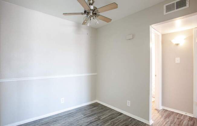 A room with a ceiling fan and light fixture.