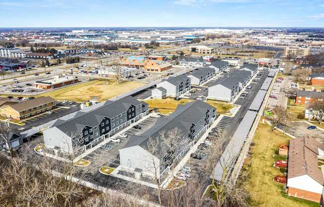 A large parking lot with several buildings in the background.
