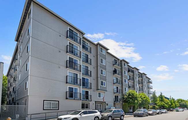 a large apartment building with cars parked in front of it at King Arthurs Court, Seattle, 98125