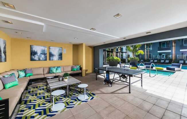 A modern living room with a pool table and a sofa.