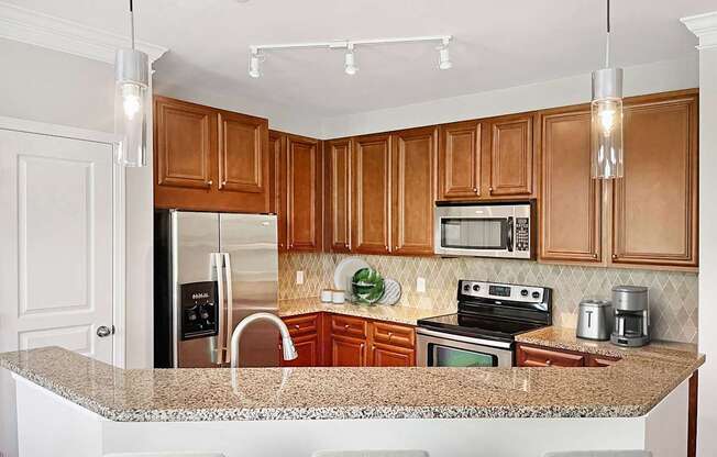 A kitchen with wooden cabinets and granite countertops.