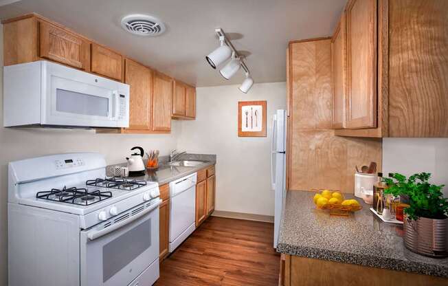 a kitchen with white appliances and wooden cabinets and a counter top