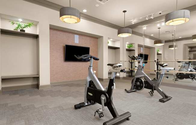 a gym with exercise bikes and a tv