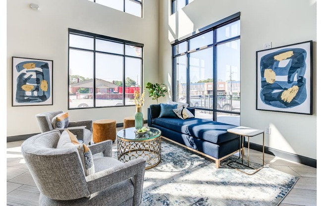 A living room with a blue sofa and two framed artworks on the wall.