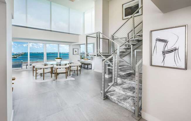 A modern interior with a staircase and a table with chairs.