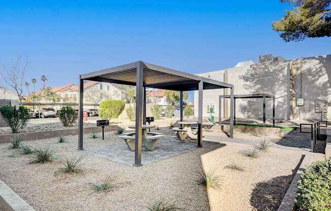 A modern outdoor seating area with a table and chairs under a roof.