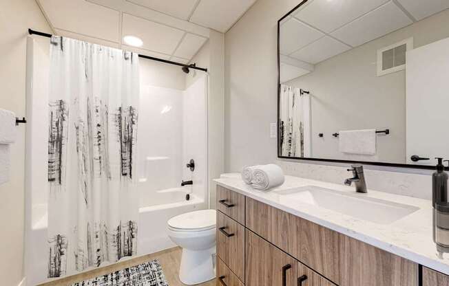 a bathroom with a toilet sink and shower in a 555 waverly unit