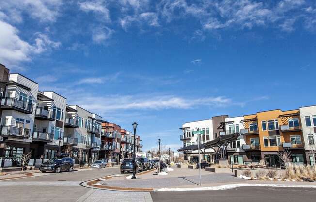 a city street with buildings on either side and a blue sky