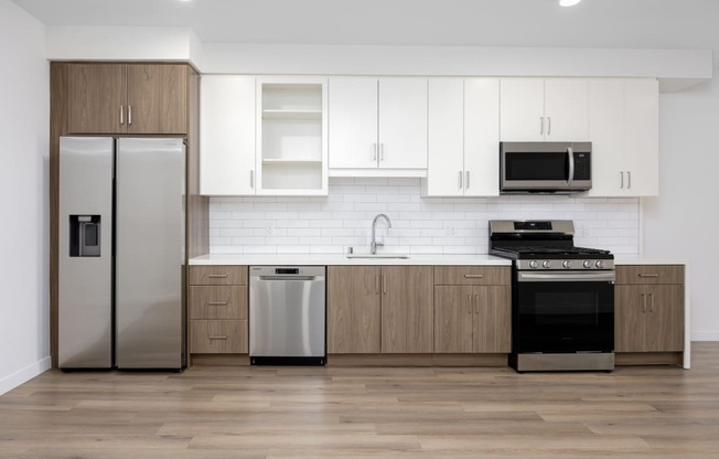 a modern kitchen with white cabinets and stainless steel appliances