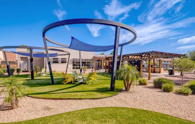 a playground with chairs and a canopy in front of a building