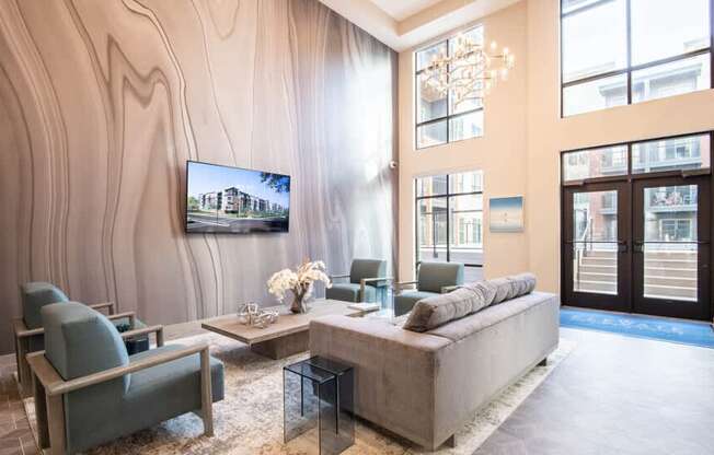 A modern living room with a grey sofa, a coffee table, and a large painting on the wall.
