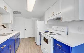 A kitchen with white cabinets and blue drawers.