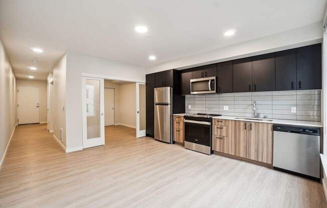 A kitchen with a refrigerator, oven, and microwave.